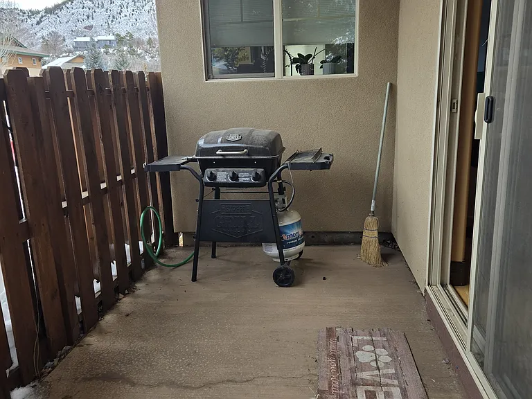 Other side of back patio. Two separate sliding glass doors enter the back patio. Not seen is a gate in the wooden fence for entrance to the sidewalk