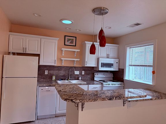 Warm, light-filled kitchen with granite counters and full amenities