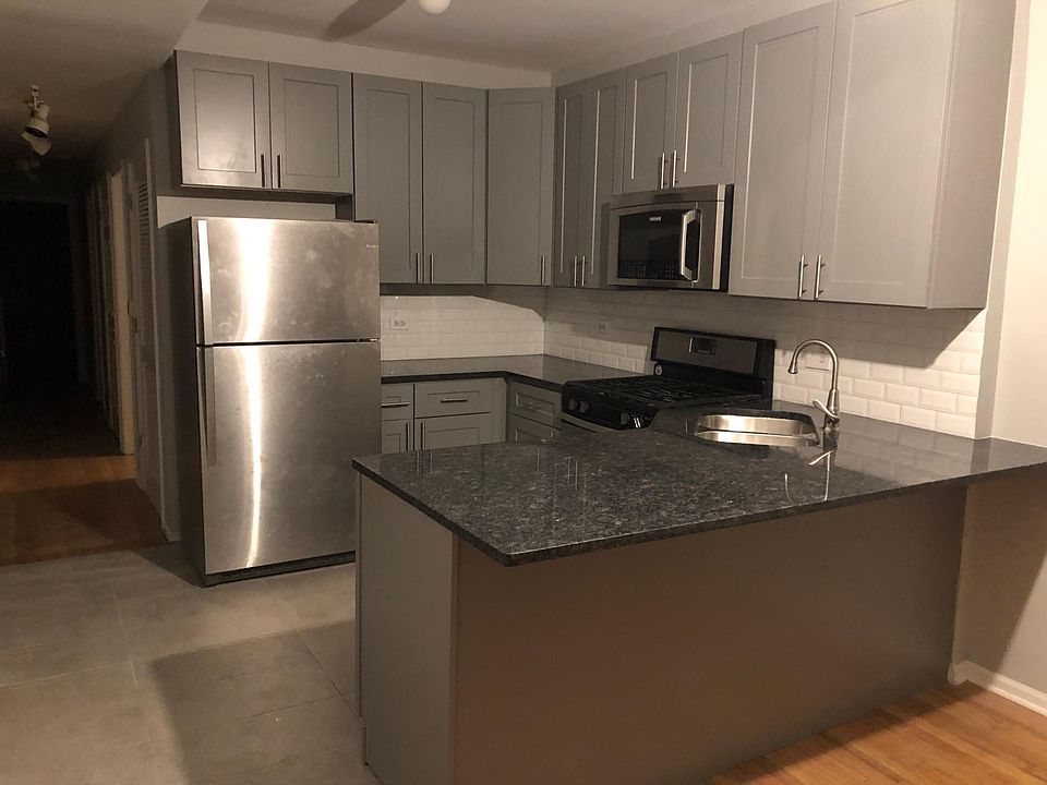 Newer kitchen with stainless steel appliances, granite countertops, tile floor and modern-looking backsplash and cabinets