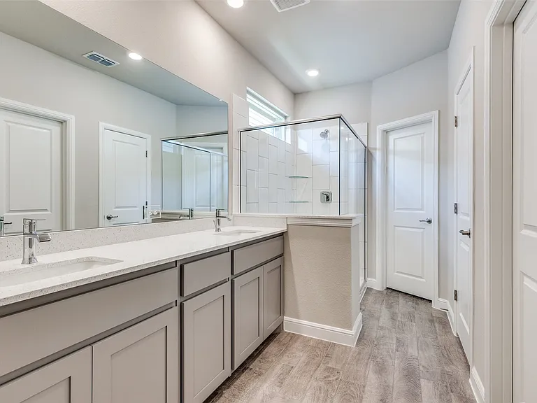 Bathroom featuring vanity, wood-type flooring, and walk in shower