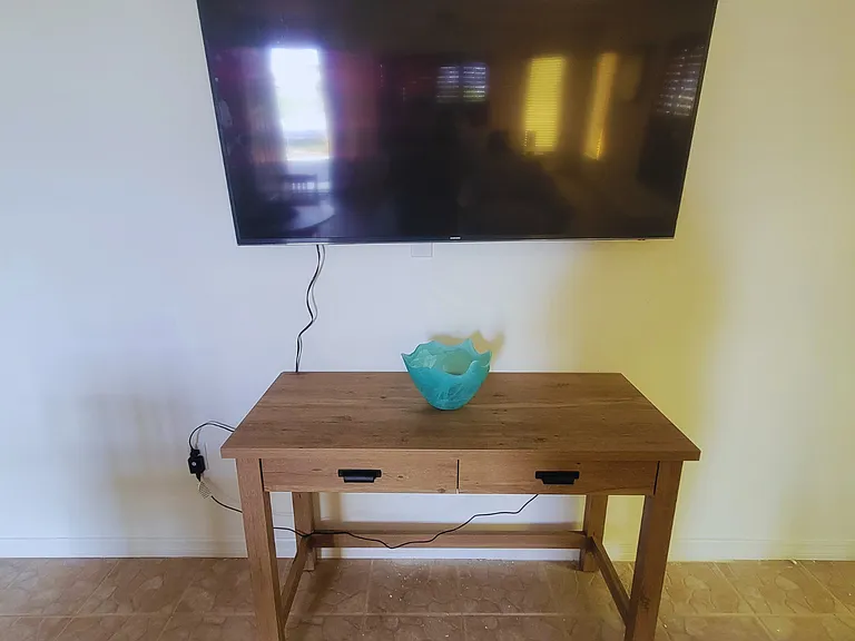 Smart TV and elegant wooden furnishings create a cozy atmosphere.