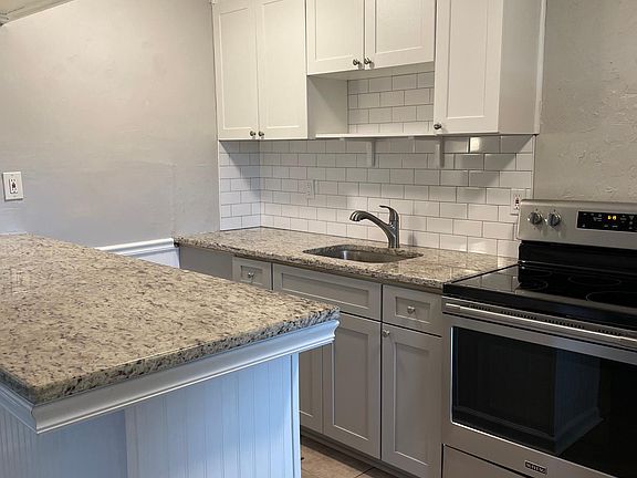 Granite countertops and subway tile backsplash. Newer kitchen cabinets.