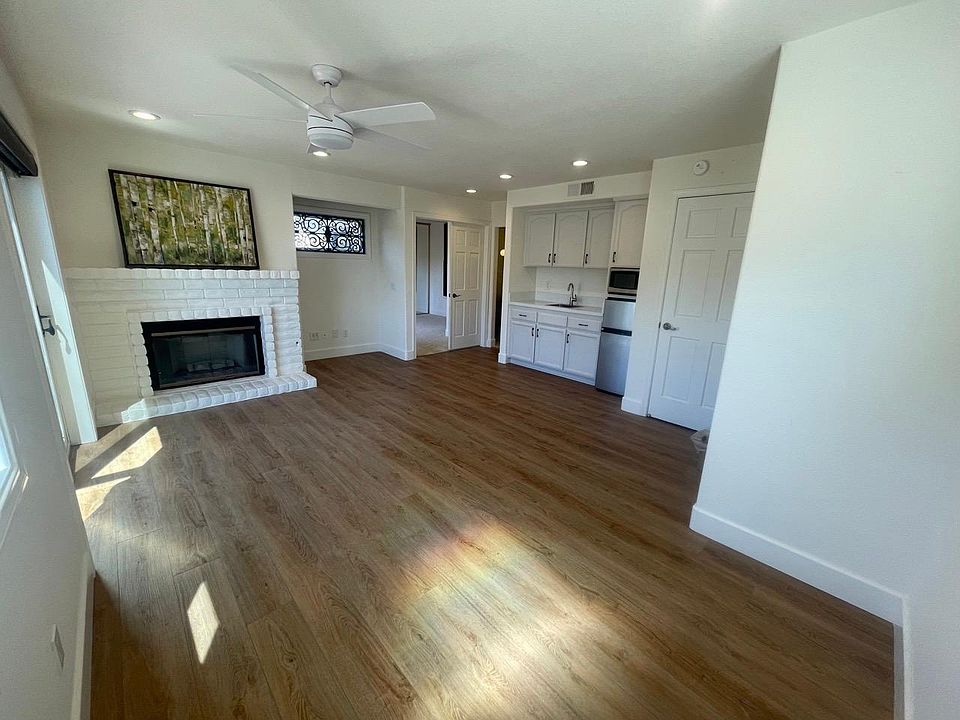Light and bright living space with fireplace, kitchenette and sliders to a small covered patio.