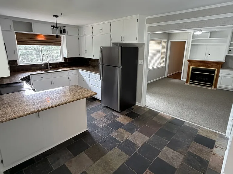 Spacious kitchen with lots of cabinets. Foldout laundry board installed in 1 of the tall cabinets.