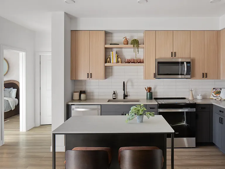 Two-tone cabinetry, open shelving, and a central island create a kitchen designed for gathering and everyday ease.