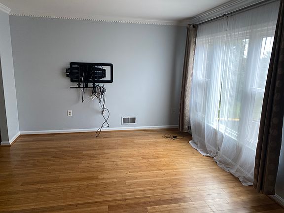 Main floor living room with large bay window overlooking driveway