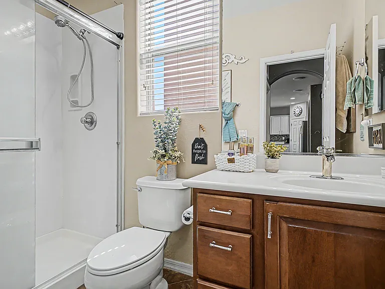 The downstairs guest bathroom features a walk-in shower with a quality shower head and ample drawer space for storing personal belongings.