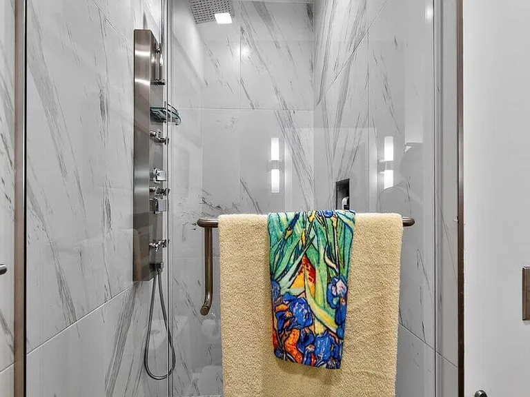 Oversized marble shower with waterfall and body jets