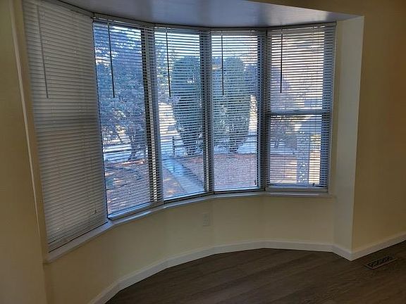 Large bay window in living room overlooking beautifully landscaped front yard.