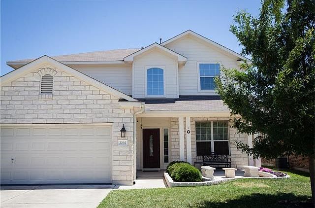 Beautiful white limestone exterior with oversized covered front porch and paved sitting area.