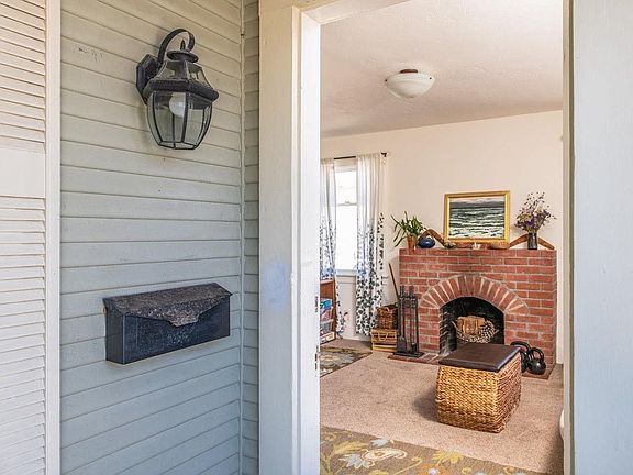 Front door leading to living room with wood burning fireplace.