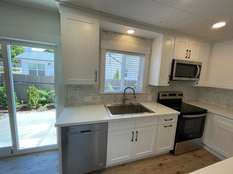 Patio off kitchen/dining, quartz counters, view from the sink out to the patio