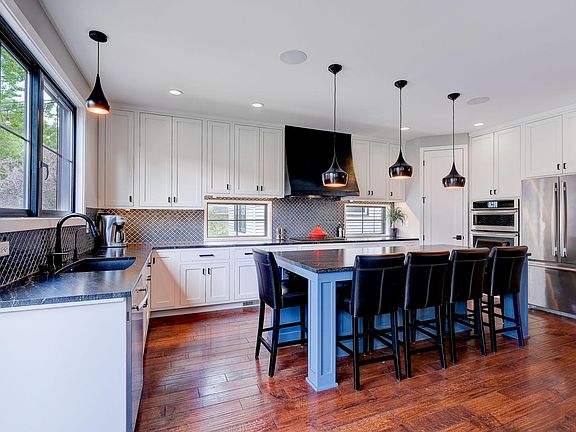 Cook with friends and family in the gourmet kitchen with custom Moroccan tile, Brazilian black granite and seating for 6 at the island.