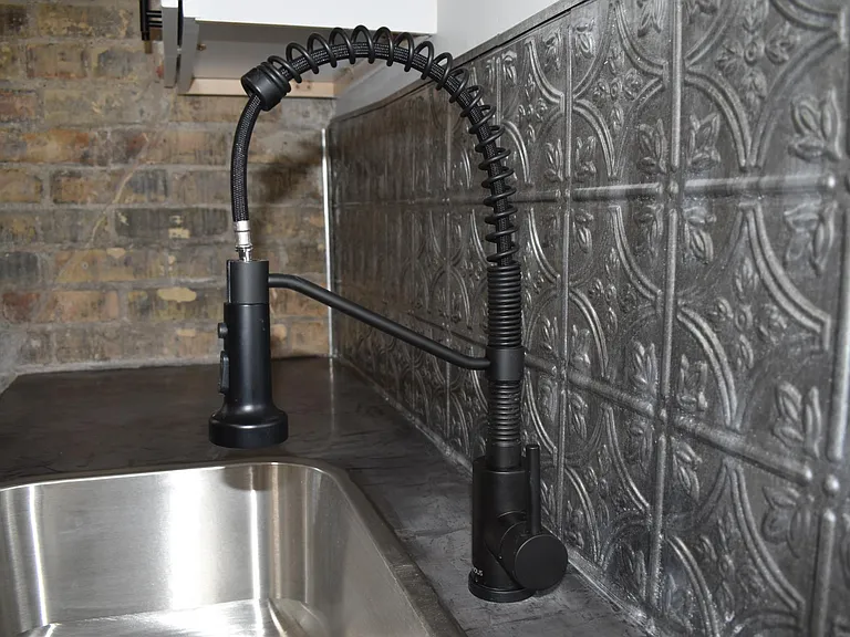 Concrete countertops, new appliances, and beautiful backsplash give this kitchen a modern industrial feel.