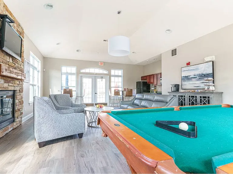View of Community Center showing pool table, fireplace, flat screen tv, seating area, and kitchenette