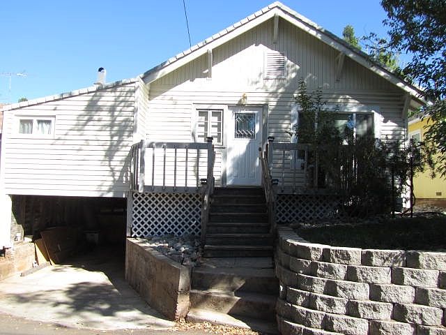 Front of house. Small carport underneath front bedroom. Livn