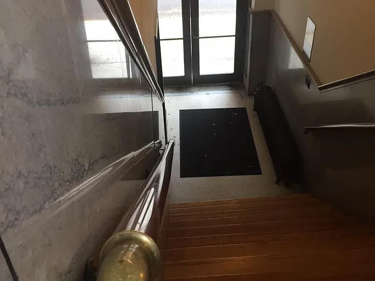 One of two building entries with 1920s marble walls, hardwoods, and bronze railings