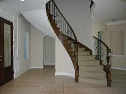 The two story entry features a dramatic curving stairway. The return stairway enters directly into t