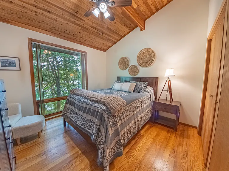 Guest bedroom with queen bed and views of water front.