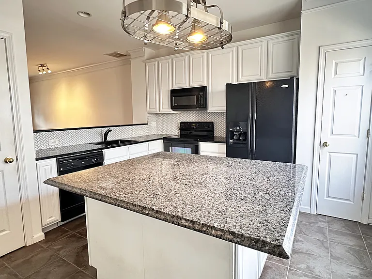 Large kitchen island with granite countertop.