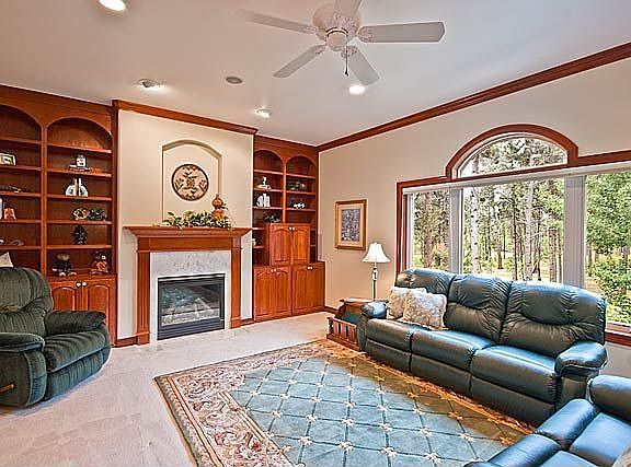 The living room features expansive windows to enjoy views of the back property