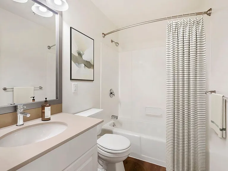 Renovated Package III bath with grey quartz countertops, white or cherry cabinetry, and hard surface flooring
