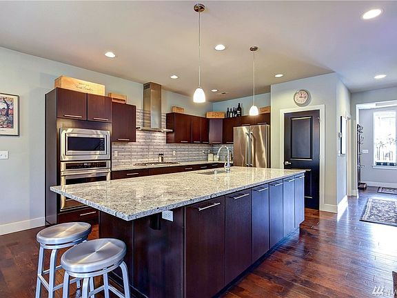 Huge granite slab island offers a convenient breakfast bar and extra storage