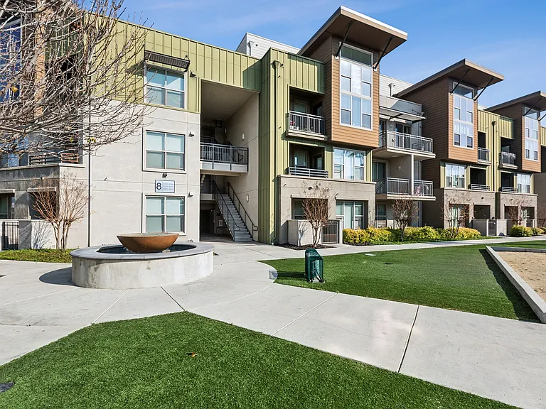 Aspire Apartments Tracy California Luxury Living Apartment complex with a fountain in the middle of a grassy area.