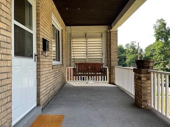 Front Porch with swing overlooking a quiet street and yard.