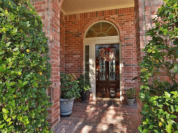 Brick paved front porch with substantial covered porch. Solid wood mahogany front door with transom and sidelight.