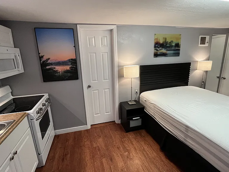 Queen bed, dual night stands with lamps, dresser, desk and chair, 65in Smart TV, full kitchen, bath.