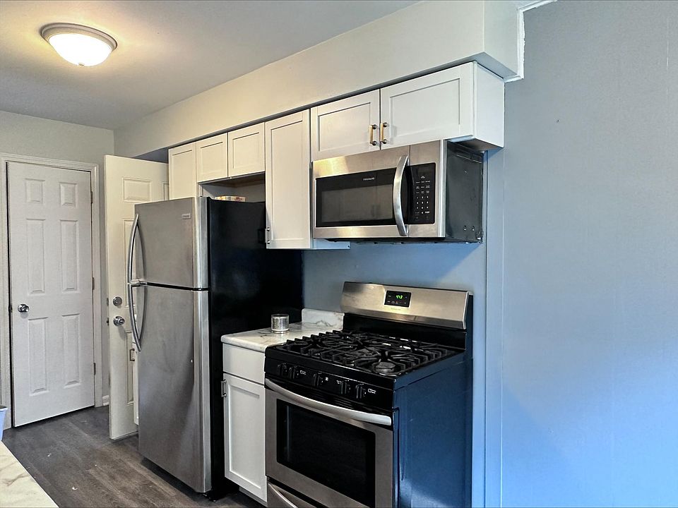 Stainless steel appliances in galley kitchen. Door leads to garage.