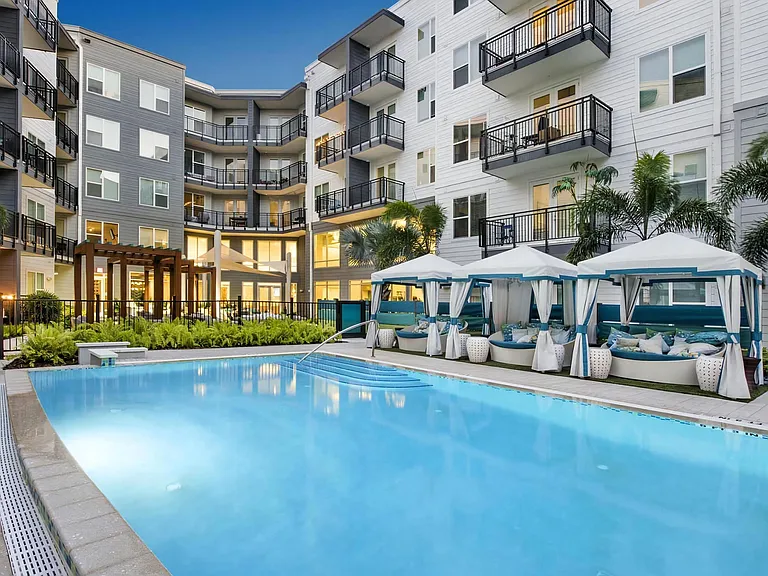 Evening Poolside Scene with Private Cabanas and Soft Courtyard Lighting