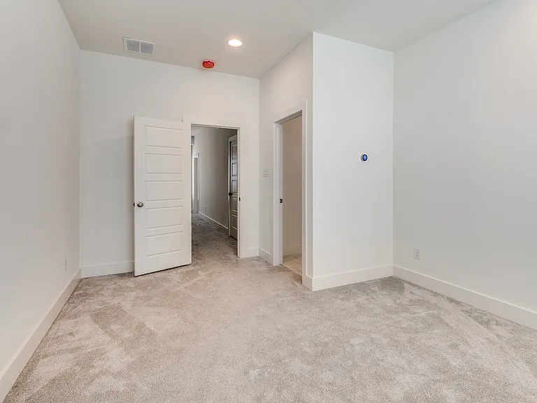 Master bedroom with ceiling fan and lots of natural sunlight showing the entrance to the private en suite full master bathroom and master walk-in closet.
