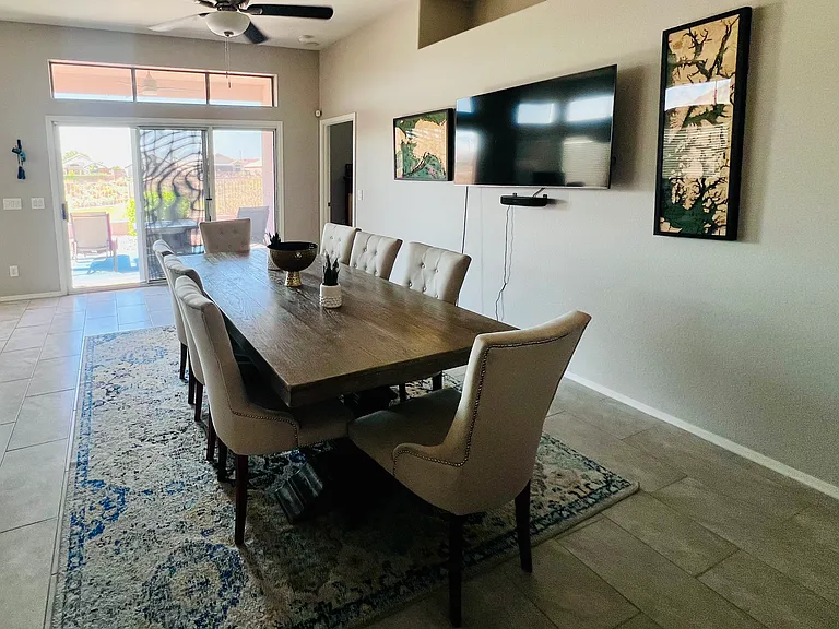 Spacious dining area. Table shown serves 8 comfortably. Area has view of patio and backyard overlooking Golf Course.