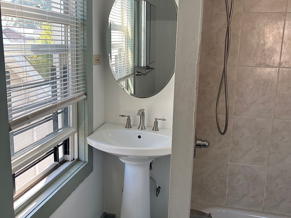 side window, pedestal sink and mirrored medicine cabinet