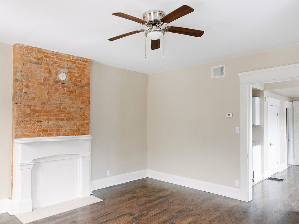 View of doorway leading to dining room/kitchen. View of exposed brick fireplace! Perfect for hanging a TV