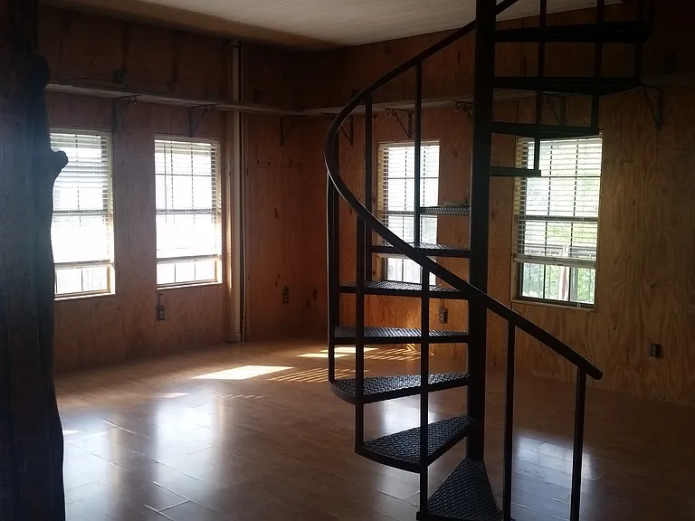 Spiral staircase leads up to storage area/bedroom with 1/2 bath