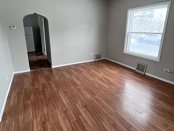 Living room with large windows and vinyl flooring.