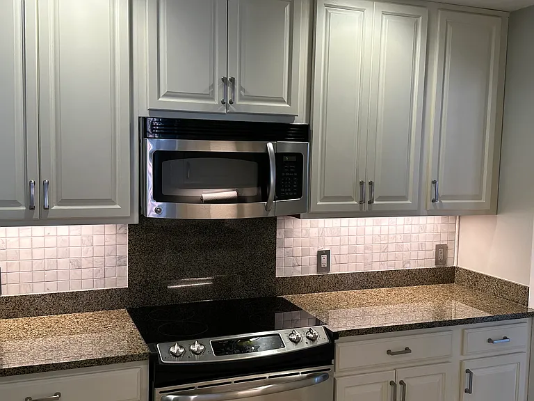 Kitchen with Electric Stove and microwave. Granite counter tops. Bosch WiFi dishwasher.