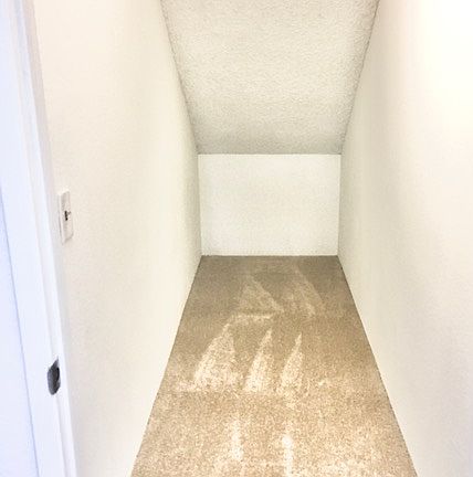Storage closet under main staircase on 1st floor, actual unit has vinyl floors.