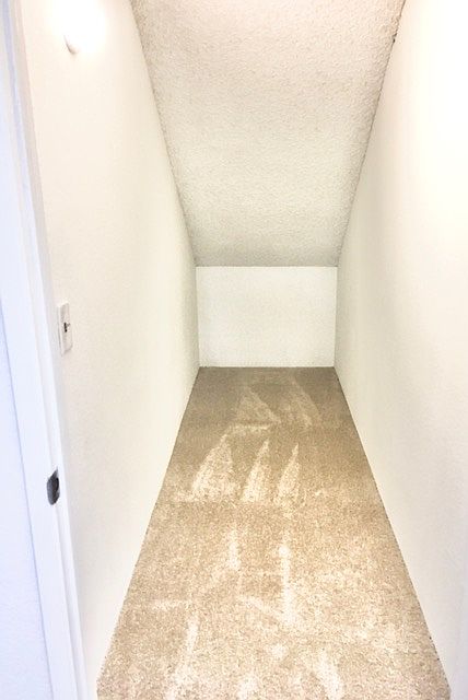 Storage closet under main staircase on 1st floor, actual unit has vinyl floors.