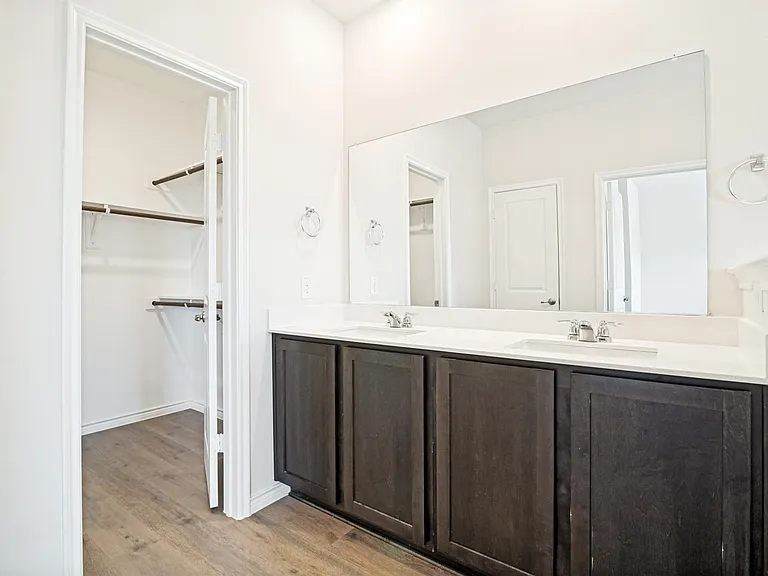Dual vanity with dark wood-finish cabinetry, white countertop, and integrated sinks