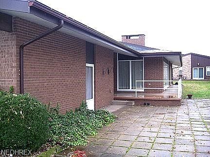 Rear view of the home showing the patio and back porch. Door to the left goes into the garage. Water and electric area available here.