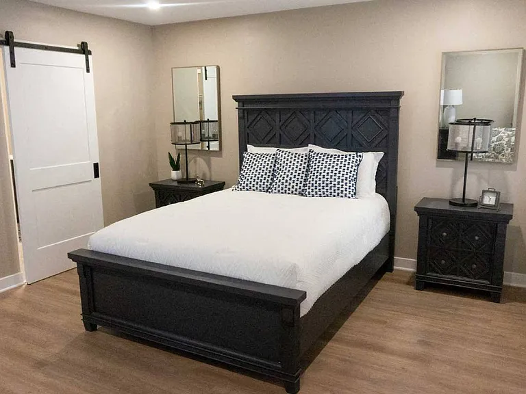 Interior of Champion Reserve Townhomes primary bedroom with doorway to ensuite bathroom and walk-in closet closed.