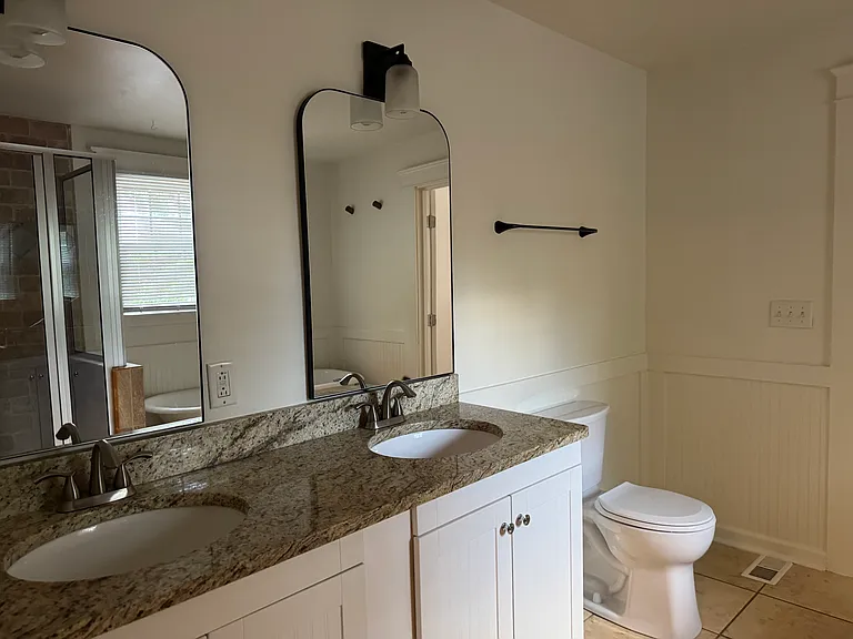 Upstairs bathroom, 2 sinks, 2 mirrors, 2 cabinets.