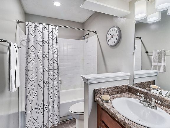 Bright bathroom with tile backsplash and bathtub
