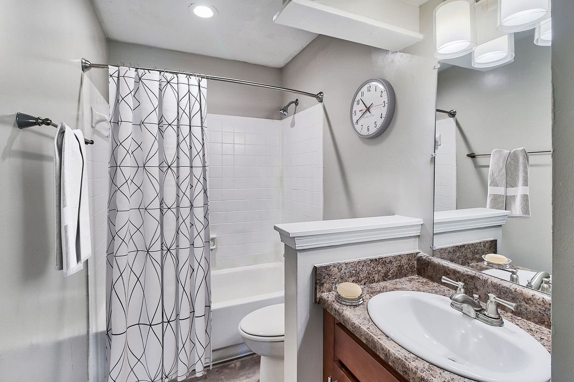 Bright bathroom with tile backsplash and bathtub