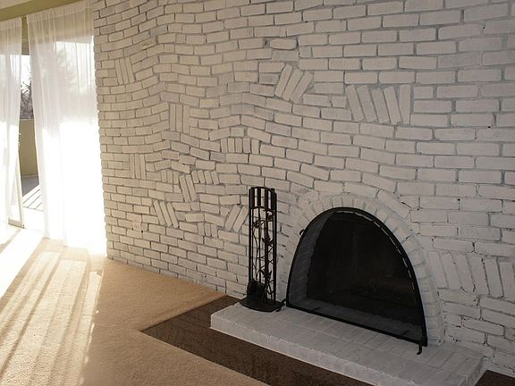 Main living area has wood-burning fireplace and easy access to sunny deck