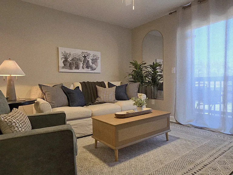 Alternate view of the bright living room with fireplace and sliding doors leading to the deck.